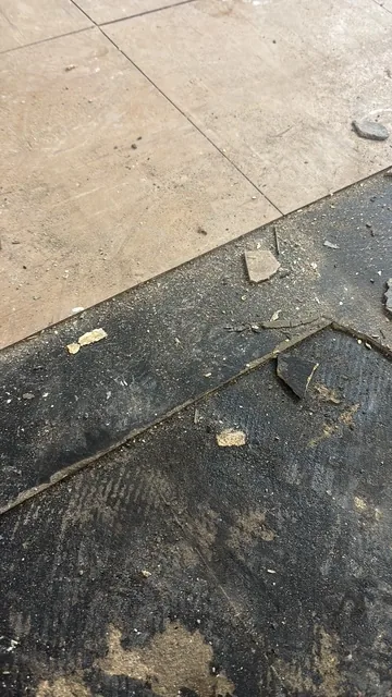 Black bitumen mastic floor removal in a E7 flat